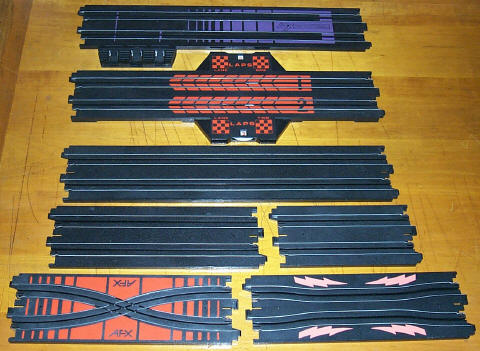 Tomy HO slot car straight track including terminal track, lap counter, 15", 9", and 6" straights, single cross straight, and squeeze track.